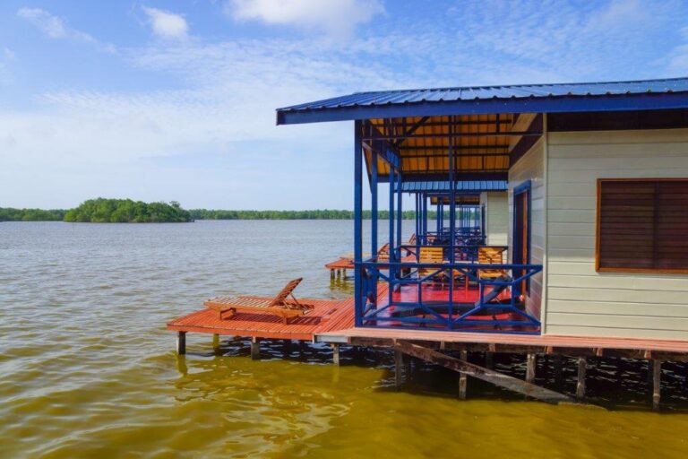 lodge met houten veranda met uitzicht over het meer in Suriname