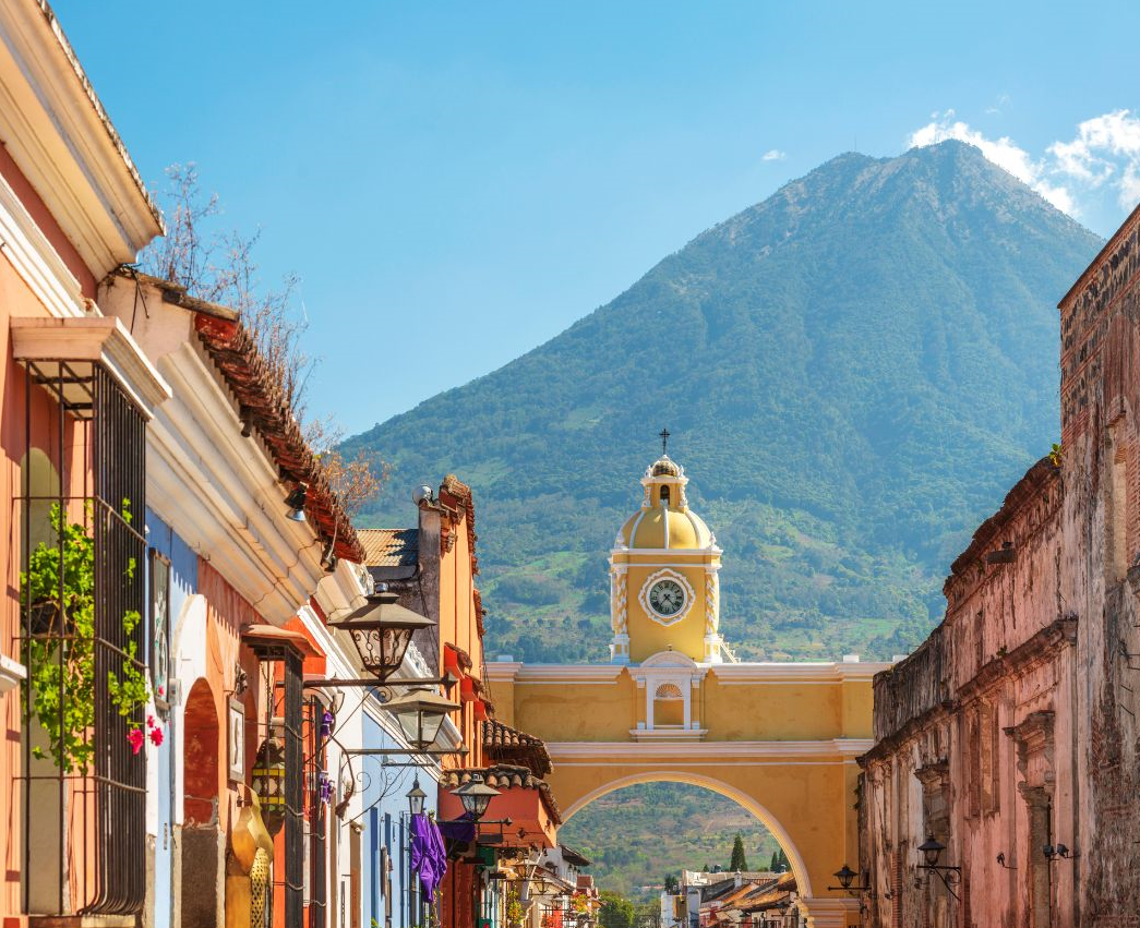 straat met gele poort en vulkaan op de achtergrond in de stad antigua in guatemala