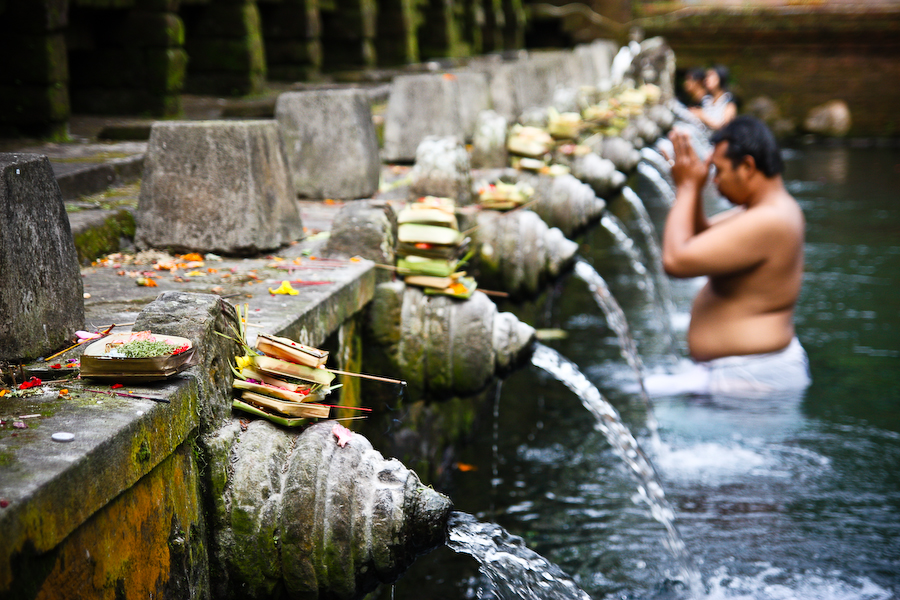 Man ondergaat een traditioneel Melukat reinigingsritueel in de hindoeïstische watertempel Pura Tirta Empul op Bali