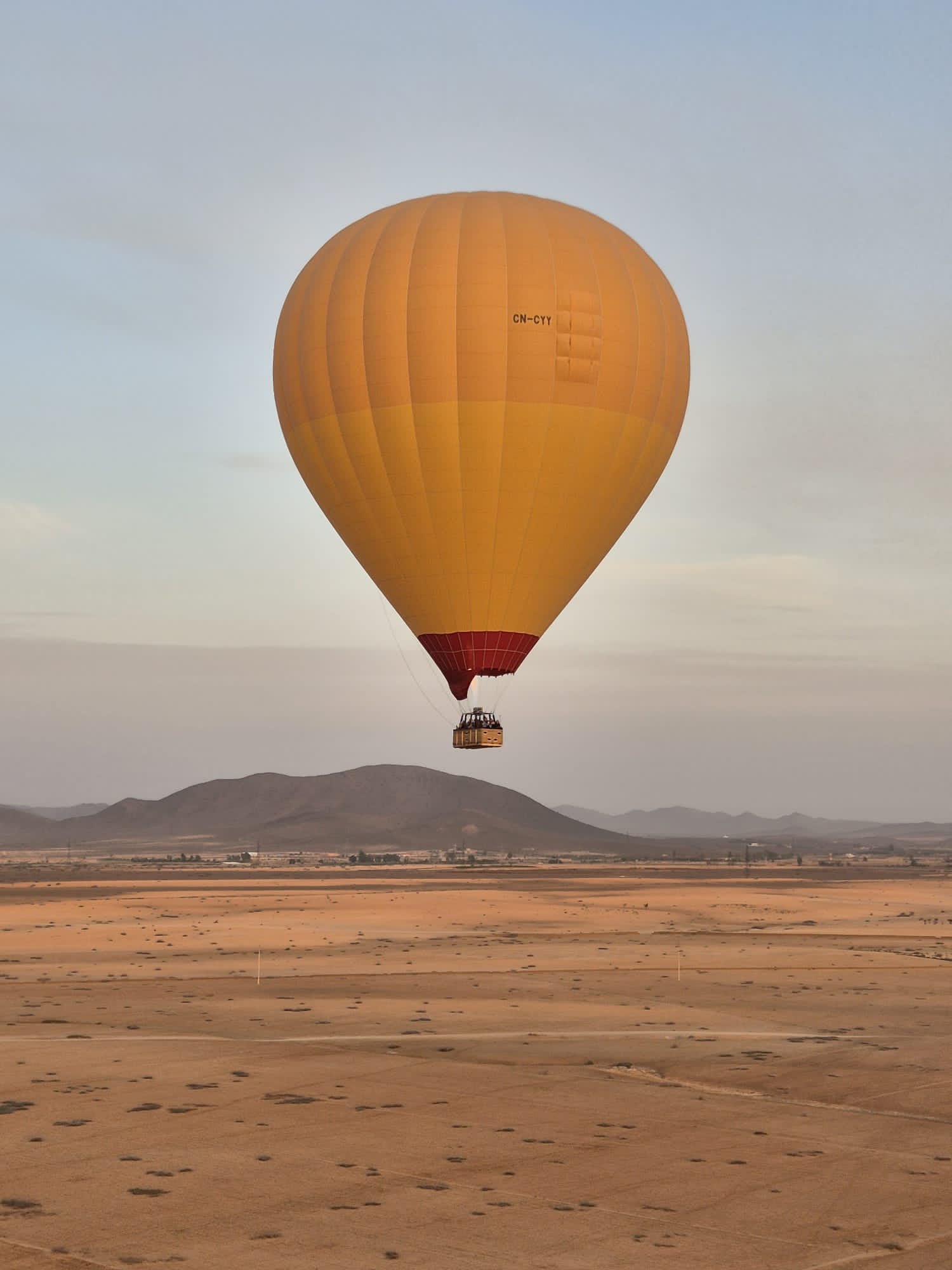 gele luchtballon boven het landschap van marokko