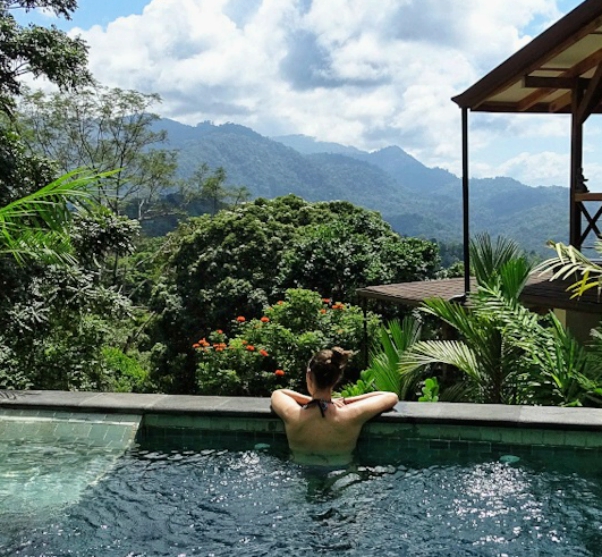 blogster sigrid kijkt vanuit zwembad over groene vallei en bergen costa rica