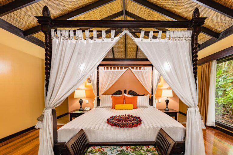 groot hemelbed in sfeervolle kamer met uitzicht op jungle groen costa rica