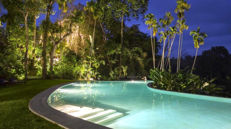 verlicht zwembad van luxe verblijf in sri lanka omgeven voor palmbomen