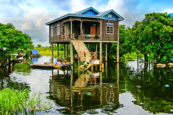 een huis langs de rivier staat op hoge palen