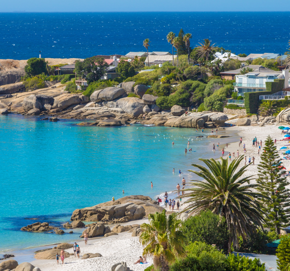 het blauwe water en witte strand van Camps Bay