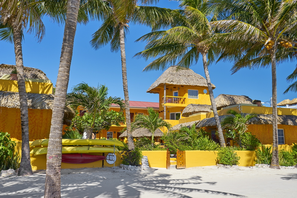 geel huis met palmbomen in caye caulker in belize