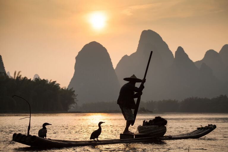 traditionele visser op de Li-rivier in China, omgeven door het iconische Karstgebergte