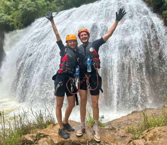 koppel staat op een rots voor een waterval