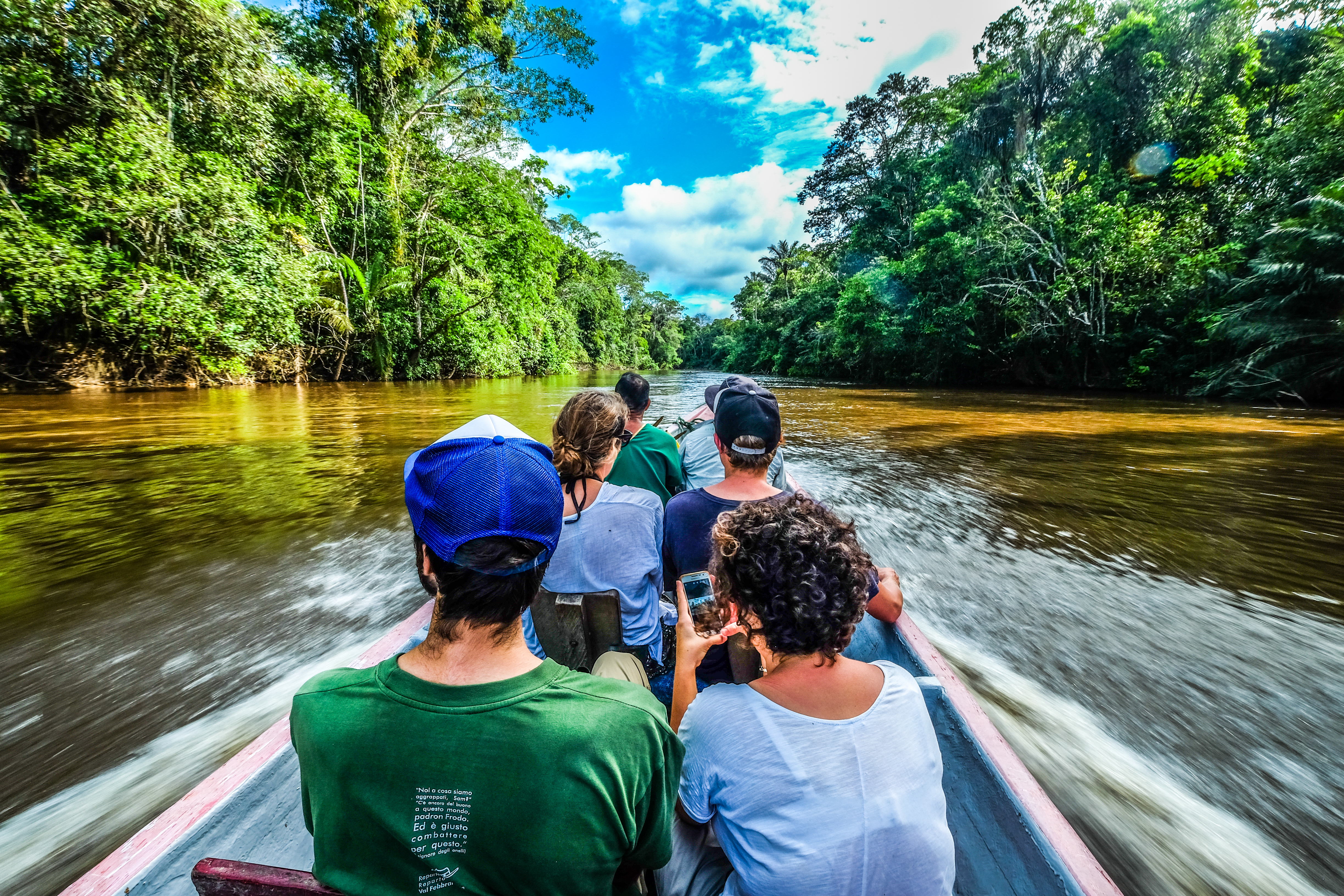 een bootje met zes toeristen vaart over de Amazonerivier
