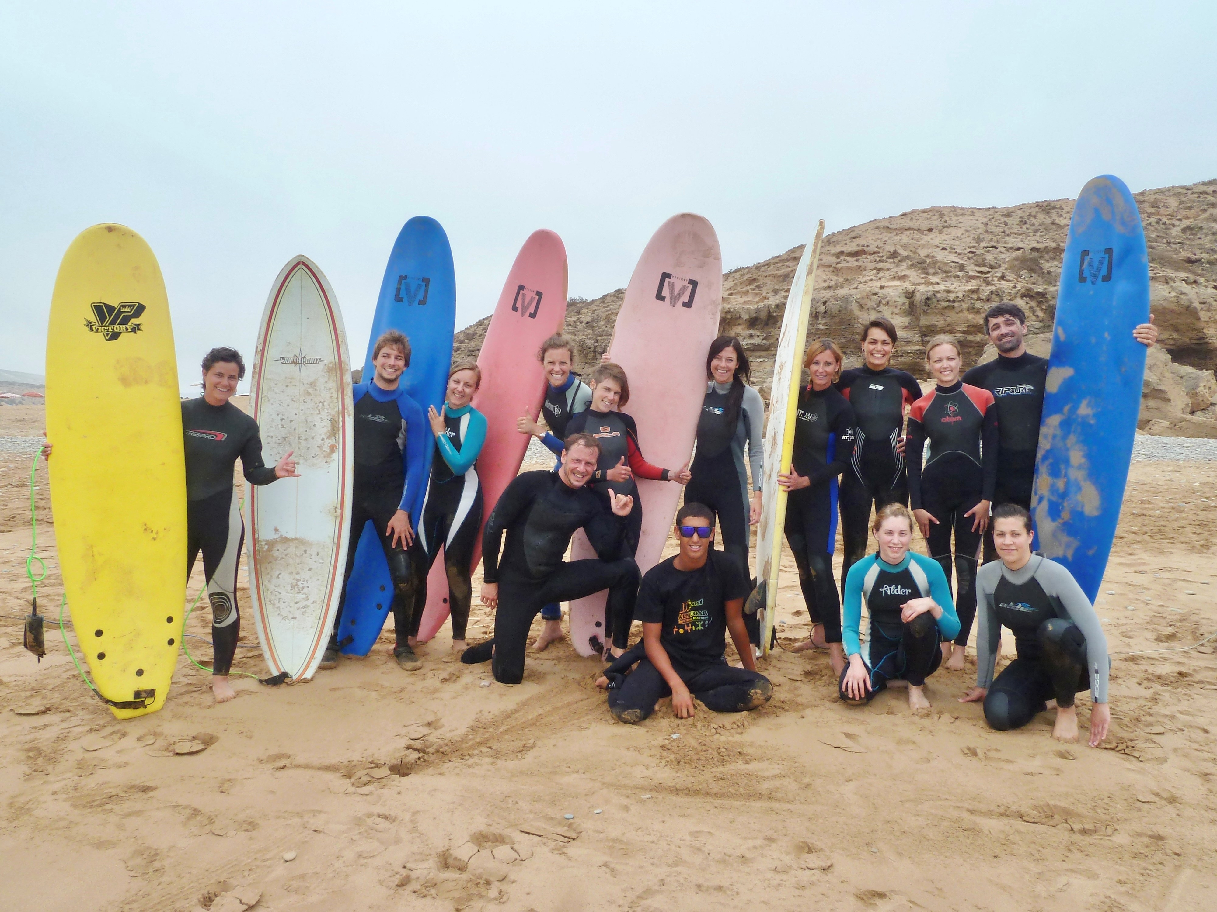 een groep surfers staan met hun board op het strand van Taghazout