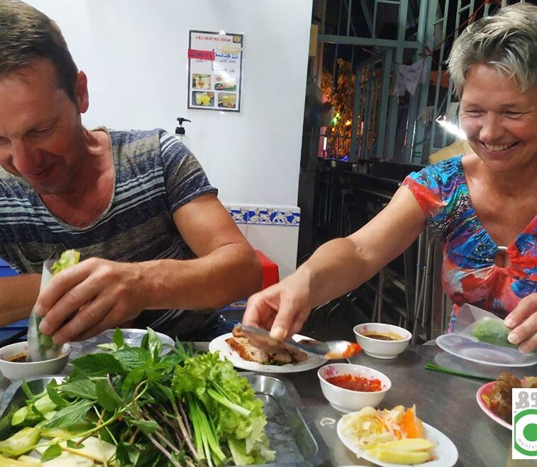 Toeristen koppel geniet van groot bord Vietnamees eten in een lokaal restaurant