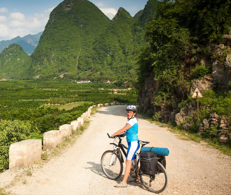 vrouw poseert op de fiets tussen karstbergen yangshuo china
