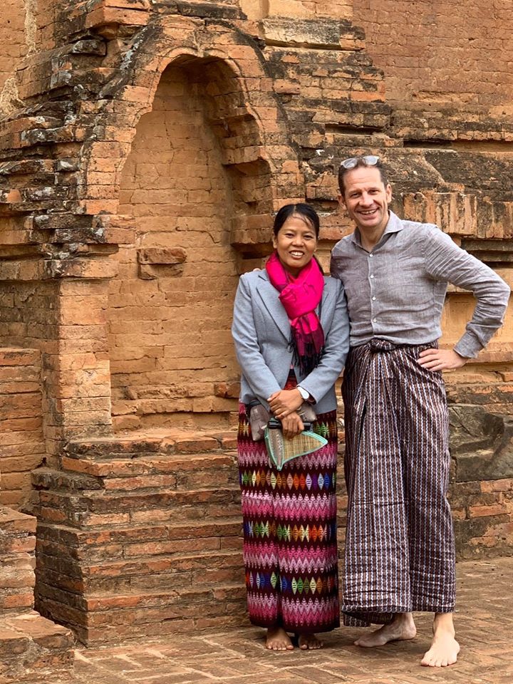 Reiziger die op de foto gaat met een lokale vrouw, beide gekleed in traditionele kleding