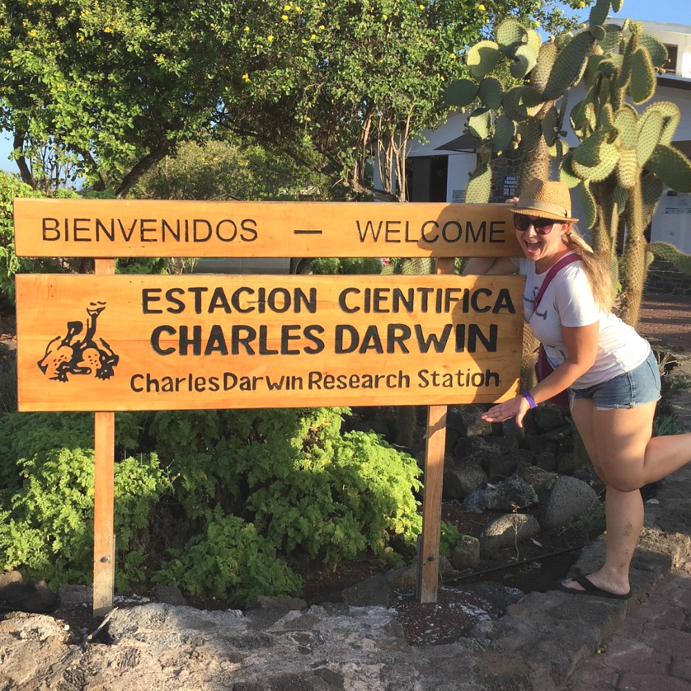 vrouw bij welkom bord op de galapagos