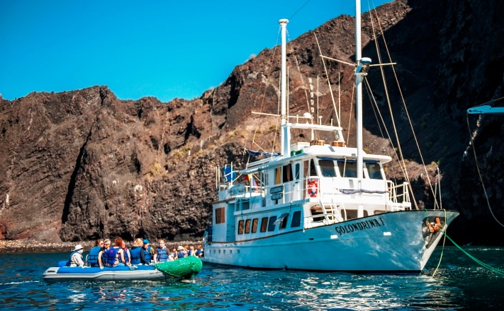 galapagos golondrina cruise boot op zee voor de kust met rotsen