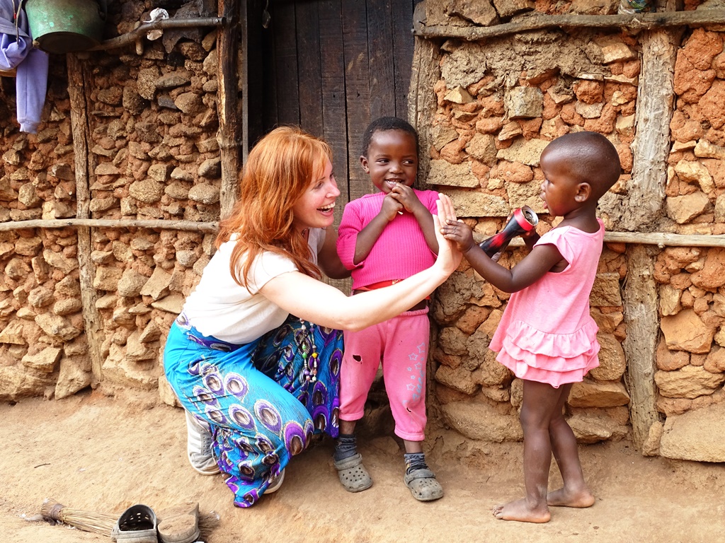 Vrouw samen met twee lokale kinderen uit Swaziland, blij en geven elkaar een high five