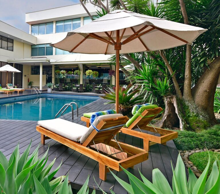 ligbedjes met parasol en tropische planten aan zwembad san josé