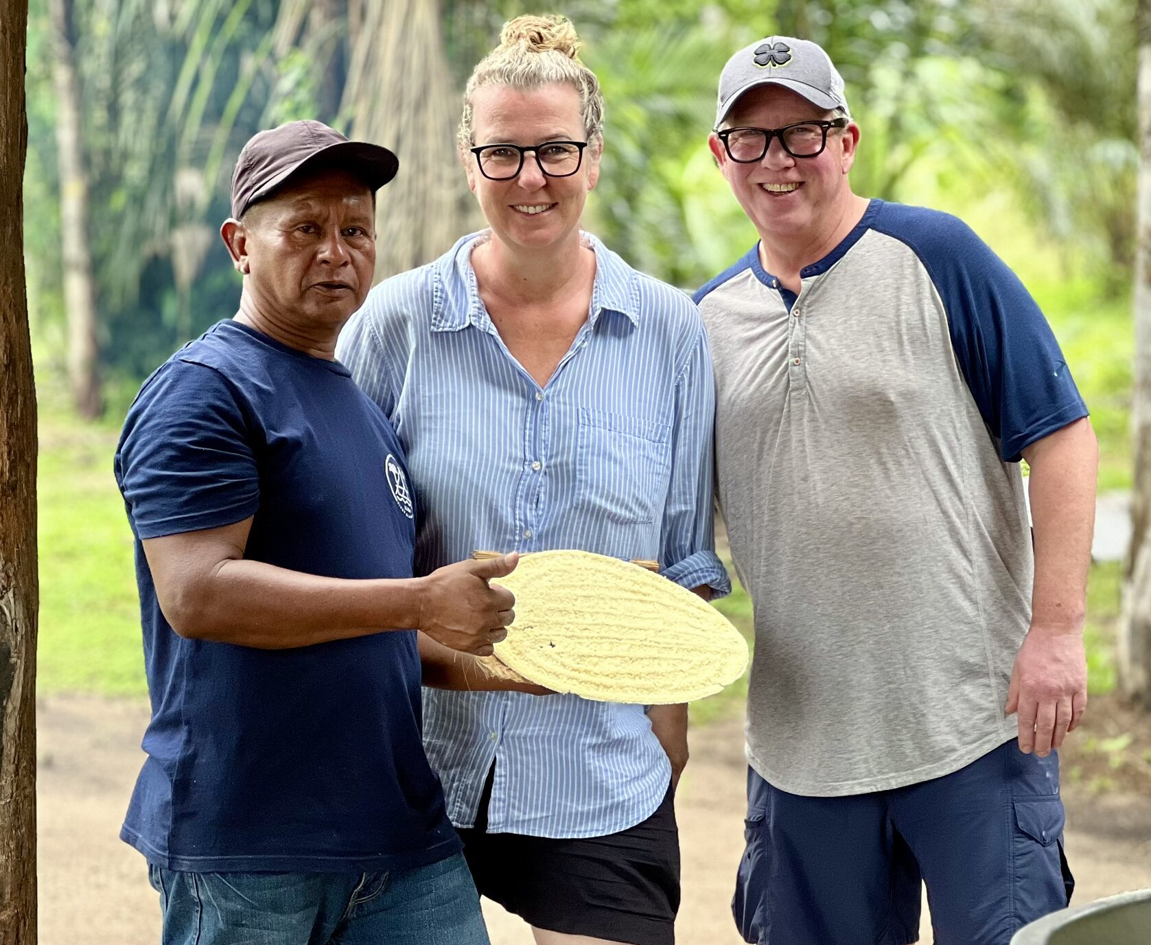 reizigers poseren naast een local in suriname, die uitleg geeft over lokale producten