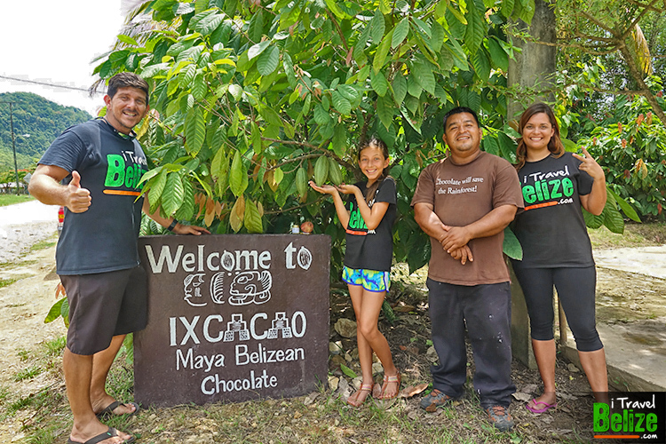 familie van de cacaoboerderij bij het welkomstbord in belize