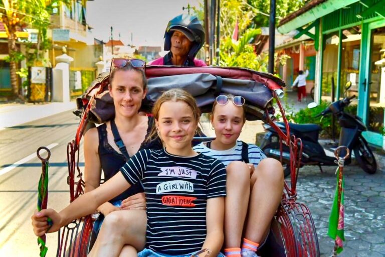vrouw met kinderen maken een riksja rit in indonesië