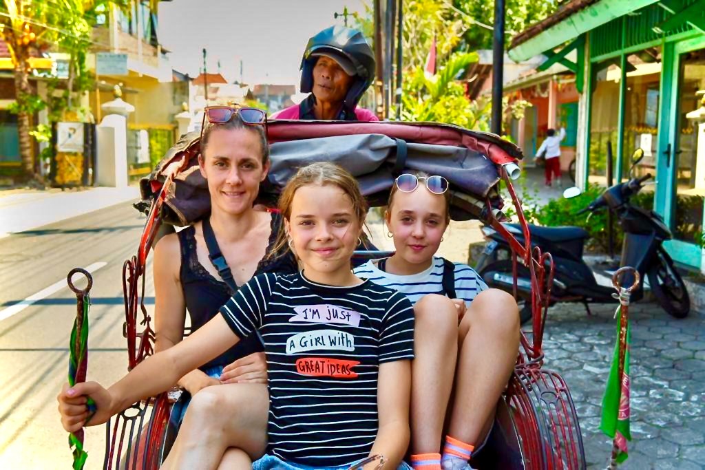 vrouw met kinderen maken een riksja rit in indonesië