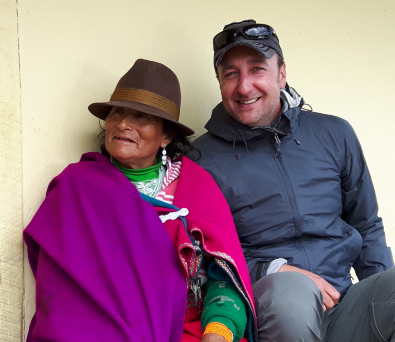 toerist zit naast een Ecuadoraanse vrouw in traditionele kleding en met een hoed op