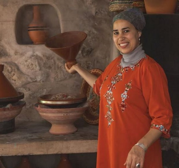 Een Marokkaanse vrouw tilt de deksel op van haar tajine