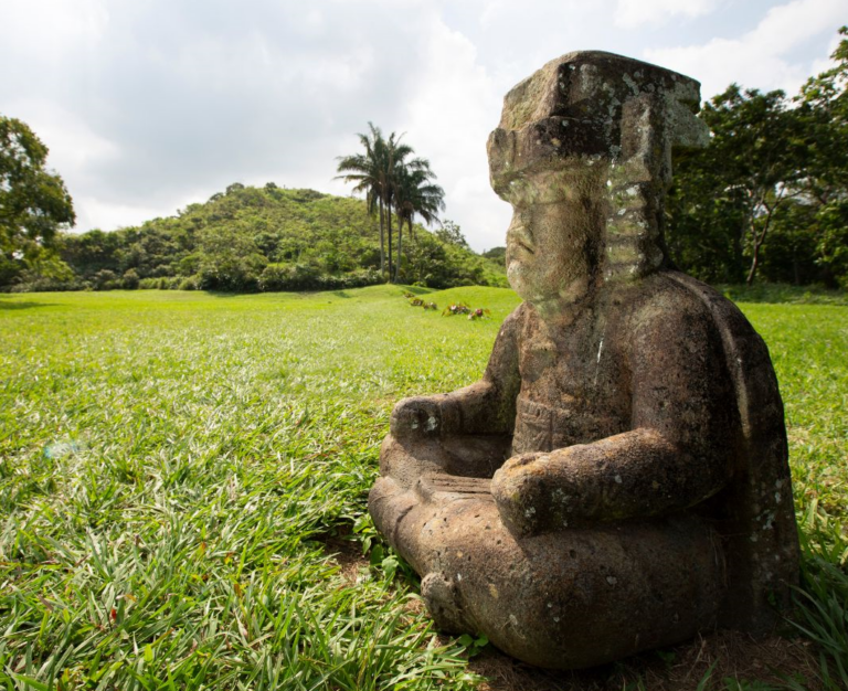 Een rots beeld in het gras met op de achtergrond bomen in Mexico