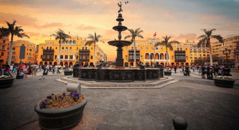 stadsplein met fontein met gele gebouwen en zonsondergang in lima