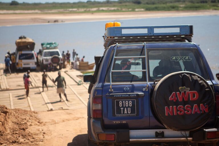 Auto ingezoomd met op de achtergrond locals, meer auto's en water in Madagaskar