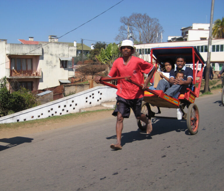 Locals in pousse pousse op de straat van Antsirabe in Madagaskar