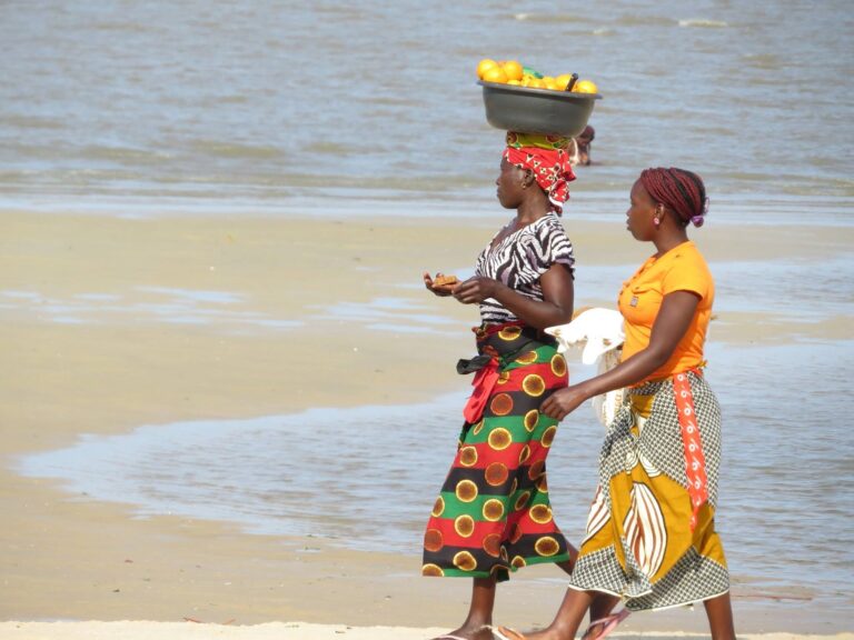 locals met fruitmand op het hoofd op het strand bij Mozambique
