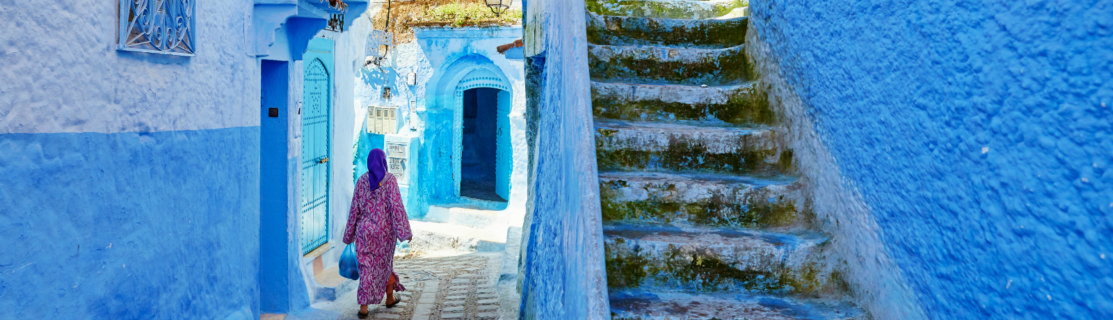 marokaanse vrouw in de blauwe straten van chefchaouen