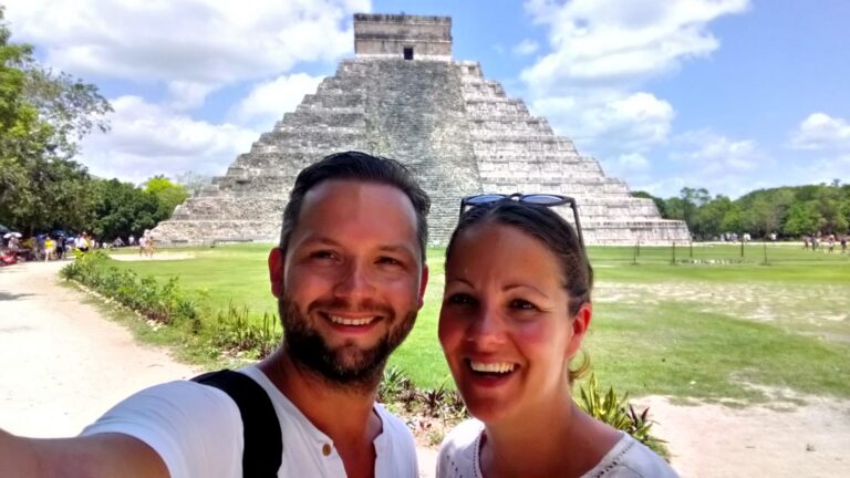 Twee reizigers lachend op een selfie met op de achtergrond Chichen Itza