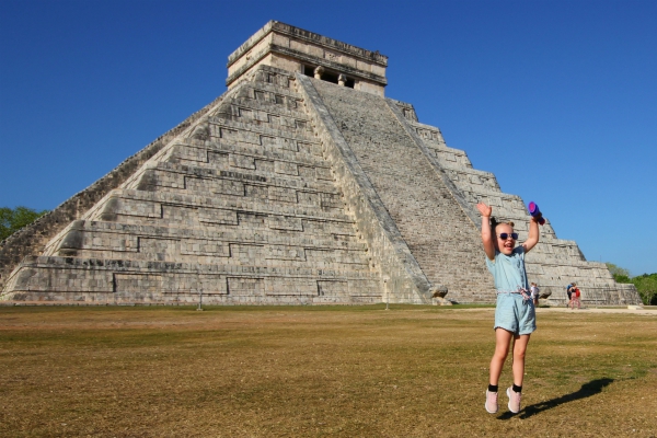 Blij kindje springend voor Chichen Itza