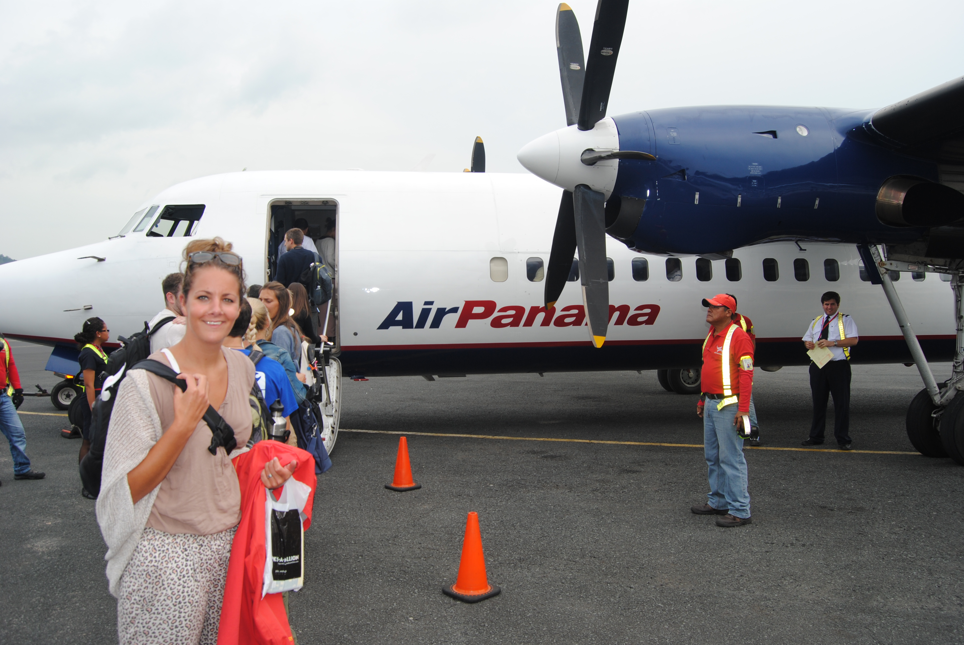 Vrouw poserend voor een klein vliegtuig van Air Panama