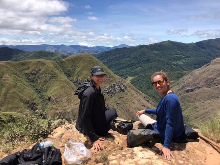 twee vrouwen zittend op een rots met op de achtergrond de bergen van de colca canyon