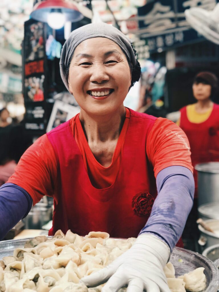 vrolijke vrouw bereidt dumplings op de markt