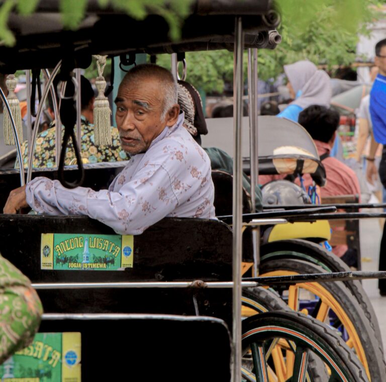 man indonesie hangt met arm over zijkant traditionele becik taxi