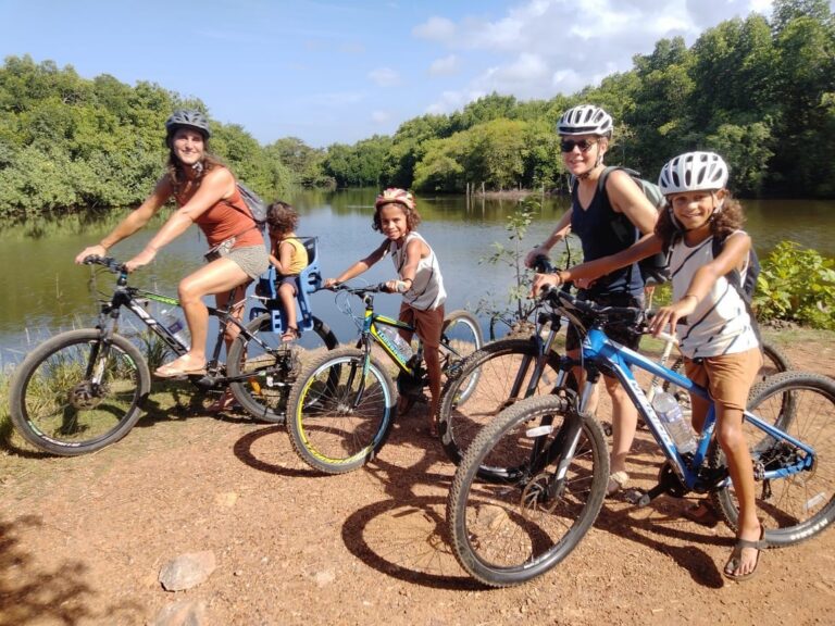 gezin poseert op fiets voor rivier in natuur sri lanka