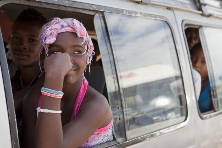 Local in Madagaskar kijkend uit het raam van een busje