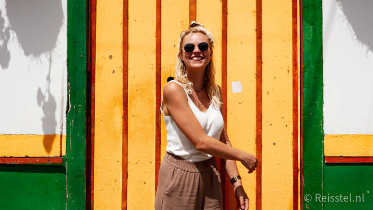 vrouw voor kleurrijk huis in salento colombia