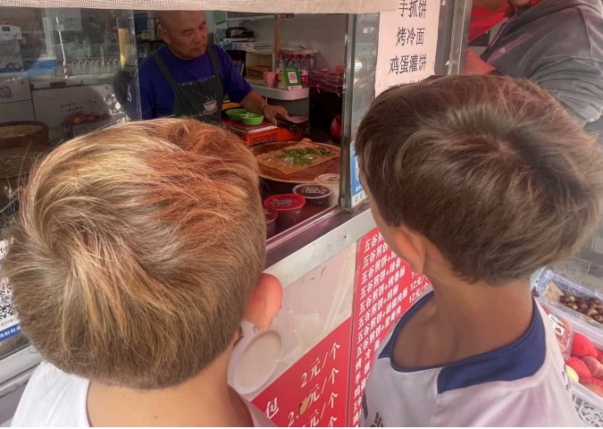 twee kinderen staan voor foodstall in china