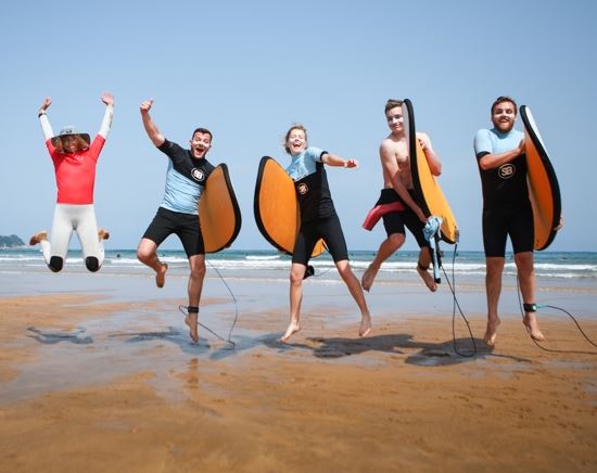 jongeren uitbundig tijdens surfles in Spanje