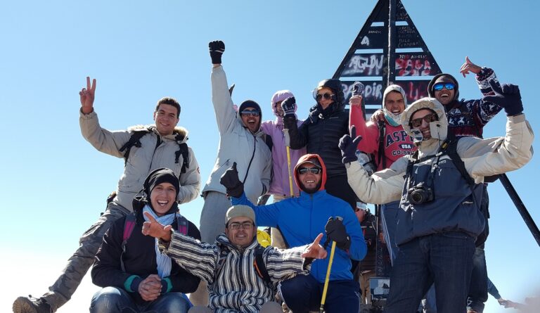 een groep hikers poseren op de top van berg Tiubkal