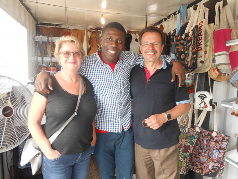 Twee reizigers samen met een local in Zuid-Afrika lachend naar de camera