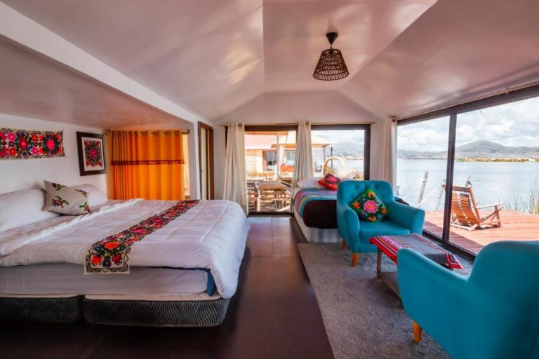accommodatie lodge met tweepersoonsbed en zithoek met uitzicht op het titicaca meer