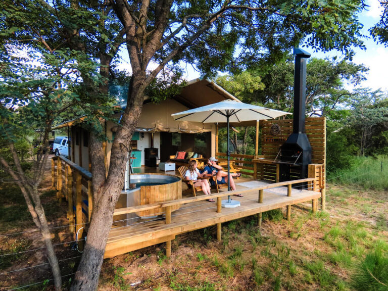 een glamping huisje met een balkon met jacuzzi en openhaard