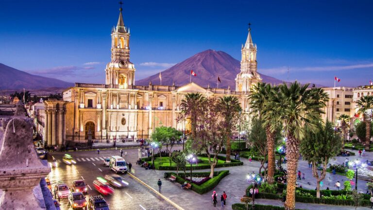 stadsplein met palmbomen en kathedraal in arequipa met bergen op de achtergrond
