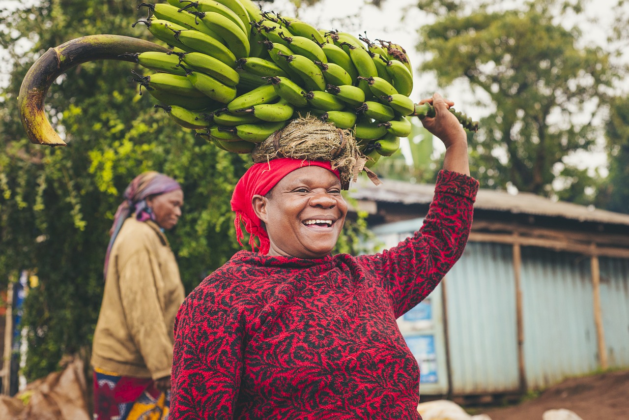 Local in Tanzania met tros bananen op haar hoofd